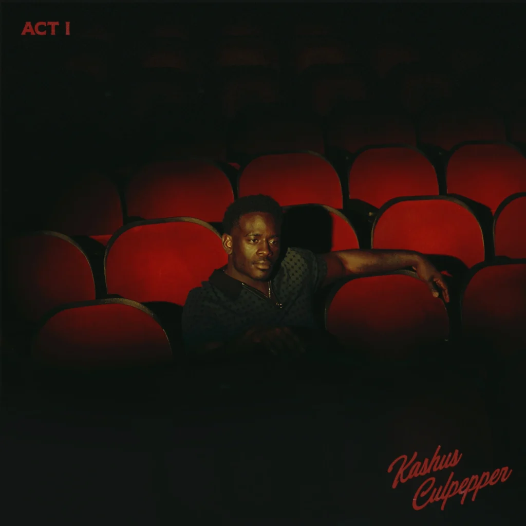 Kashus Culpepper posing in an empty auditorium on the cover art for his debut album 'ACT I.'